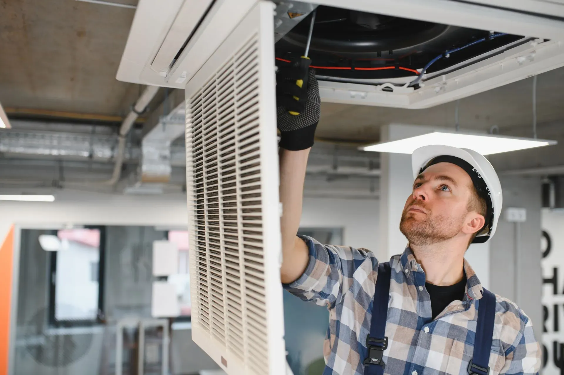 HVAC technician servicing indoor heating and cooling equipment